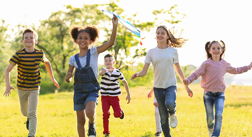 Cute little children running and playing with kite outdoors on sunny day