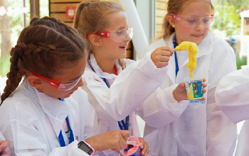 Kids making pink and yellow slime.