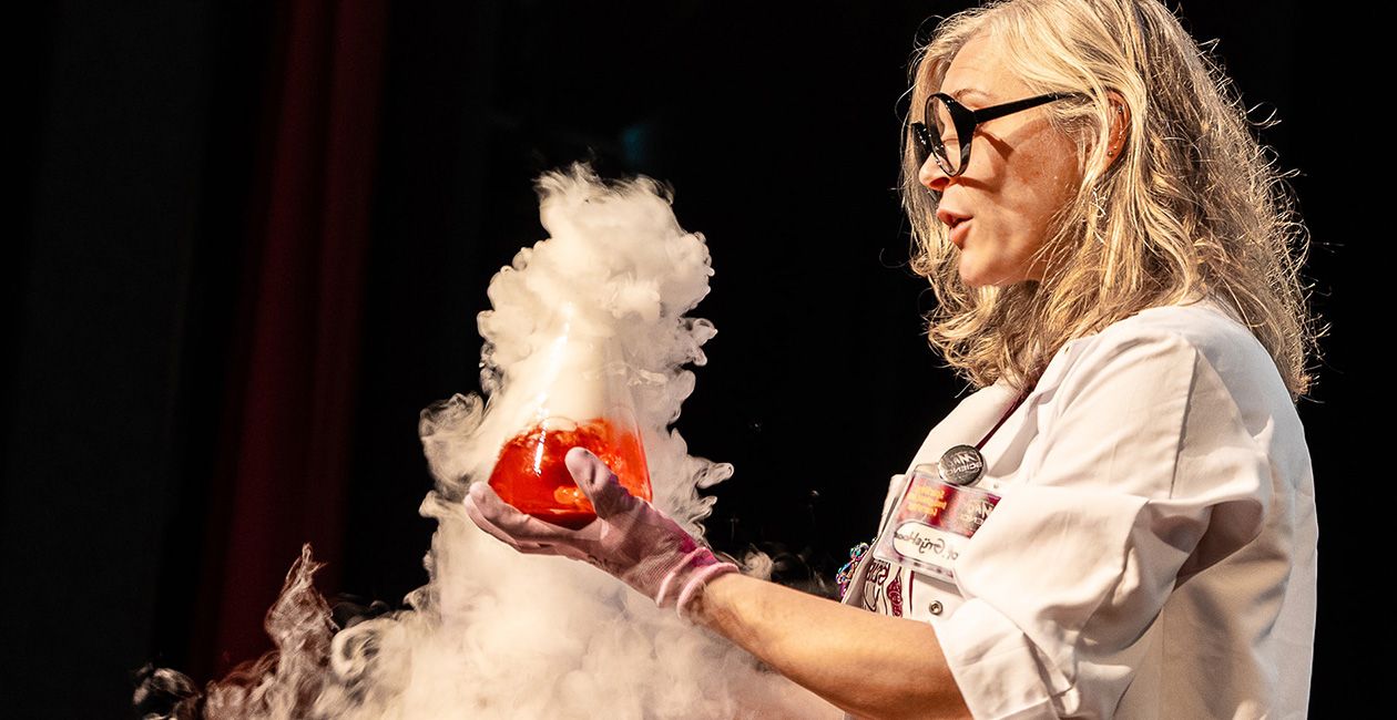 Mad scientist holding a beaker with a red liquid inside and smoke pouring out of it