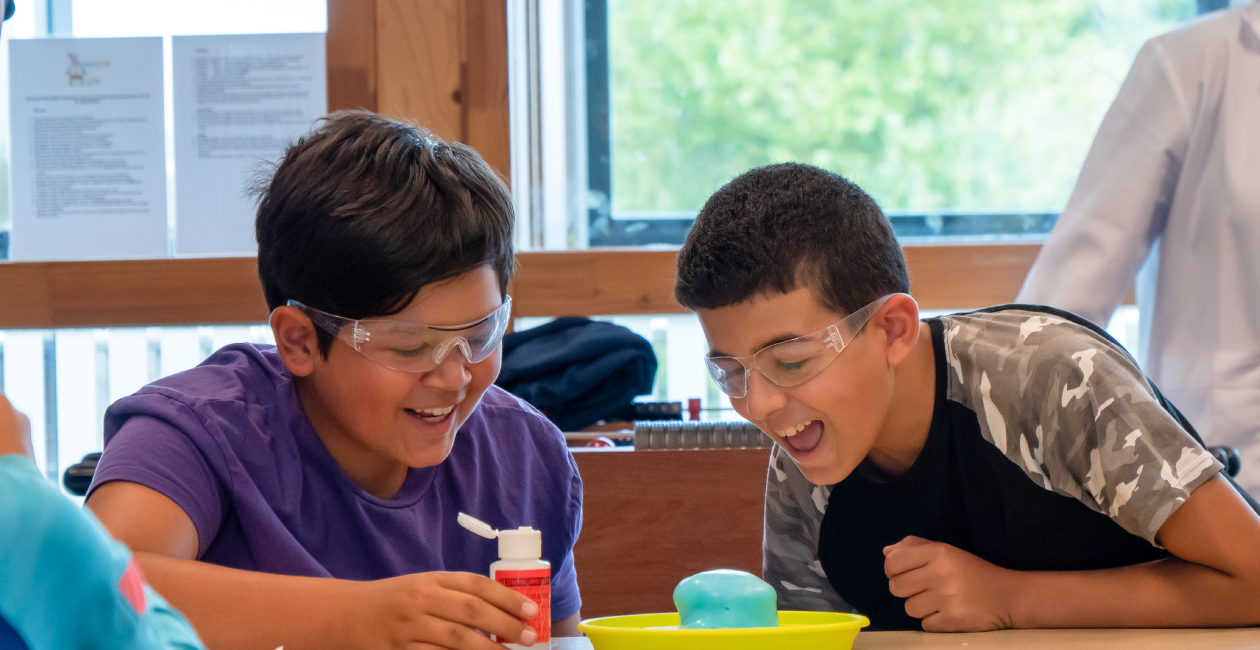 Kids in a classroom doing a baking soda and vinegar reaction experiment.
