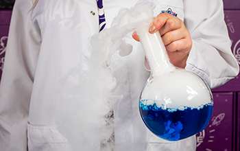 Mad Scientist swirling dry ice in a round-bottom flask.