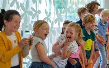 Kids standing in a row, laughing.