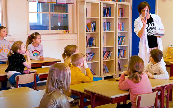 An instructor teaching a class of kids about science.